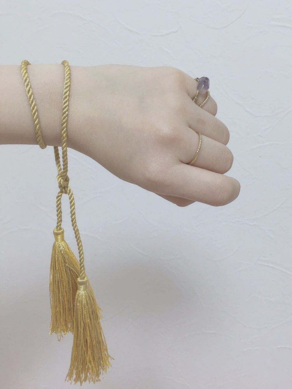 イエロー系のブレスレットを着用したレディースの春コーディネートの1枚目の写真