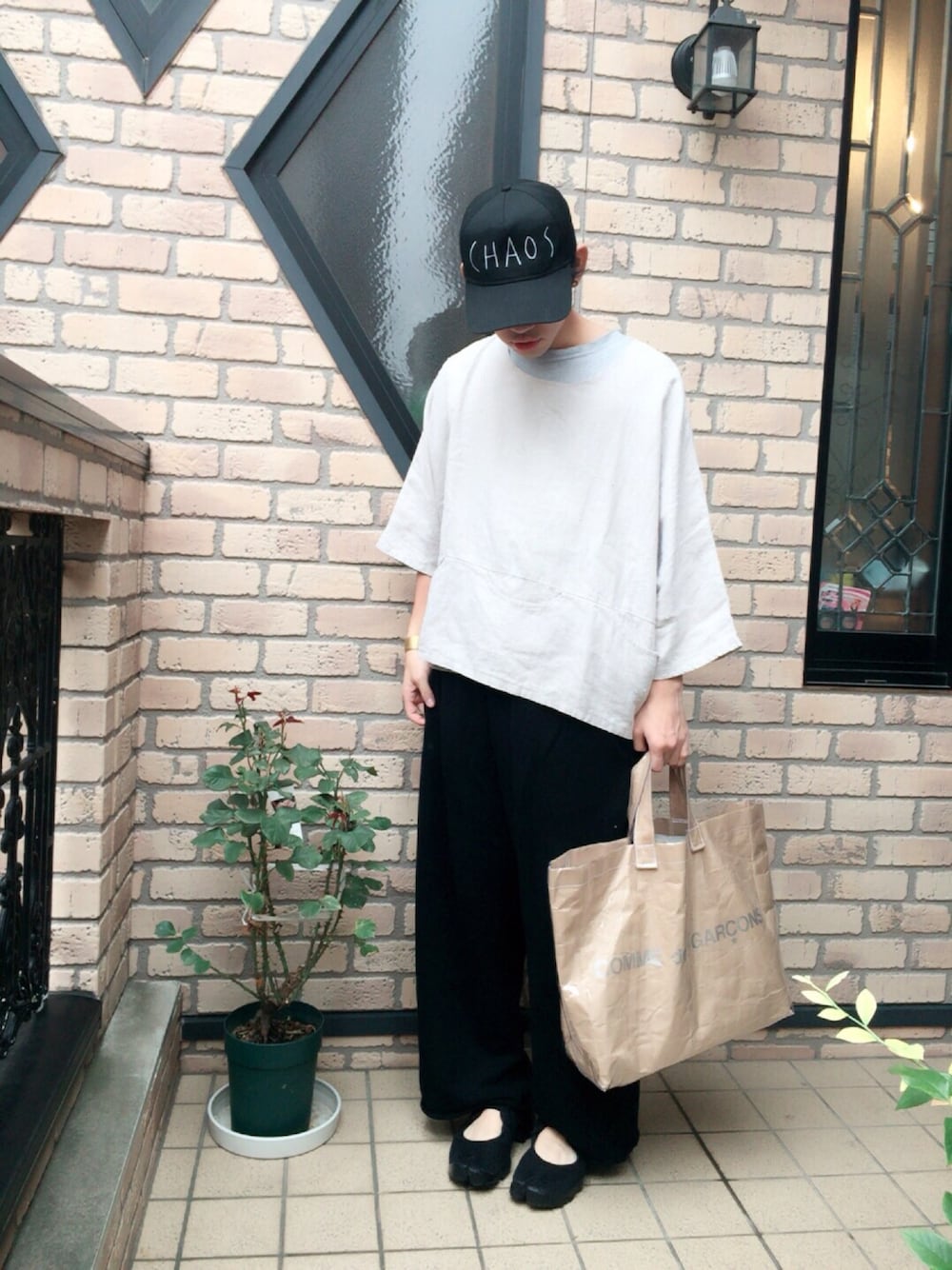 ベージュ系のTシャツ/カットソー、ブラック系のパンツ、ベージュ系のトートバッグを着用したメンズの夏コーディネートの1枚目の写真