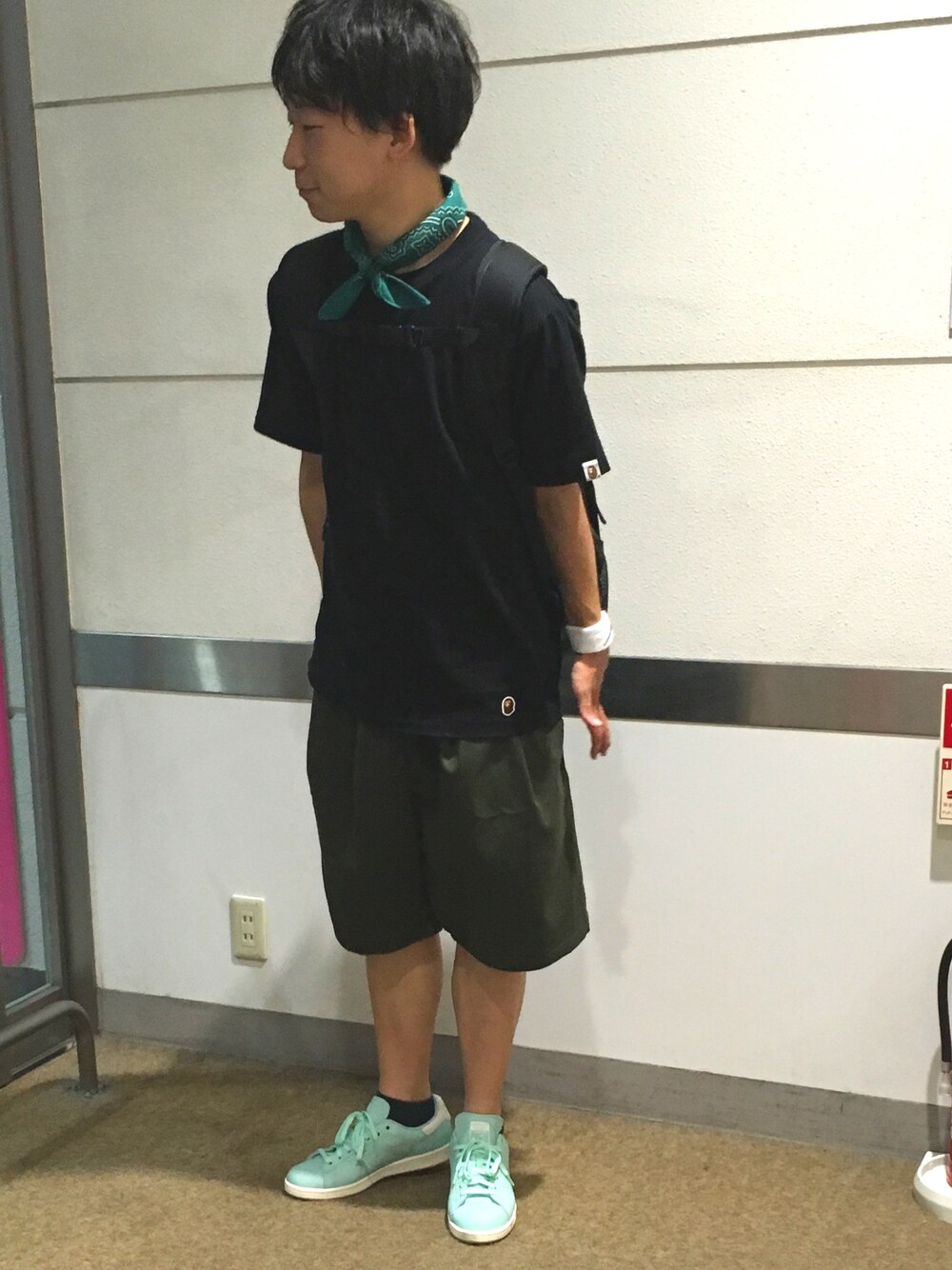 ブラック系のTシャツ/カットソー、グリーン系のその他パンツ、ブルー系のスニーカーを着用したメンズの秋コーディネートの1枚目の写真