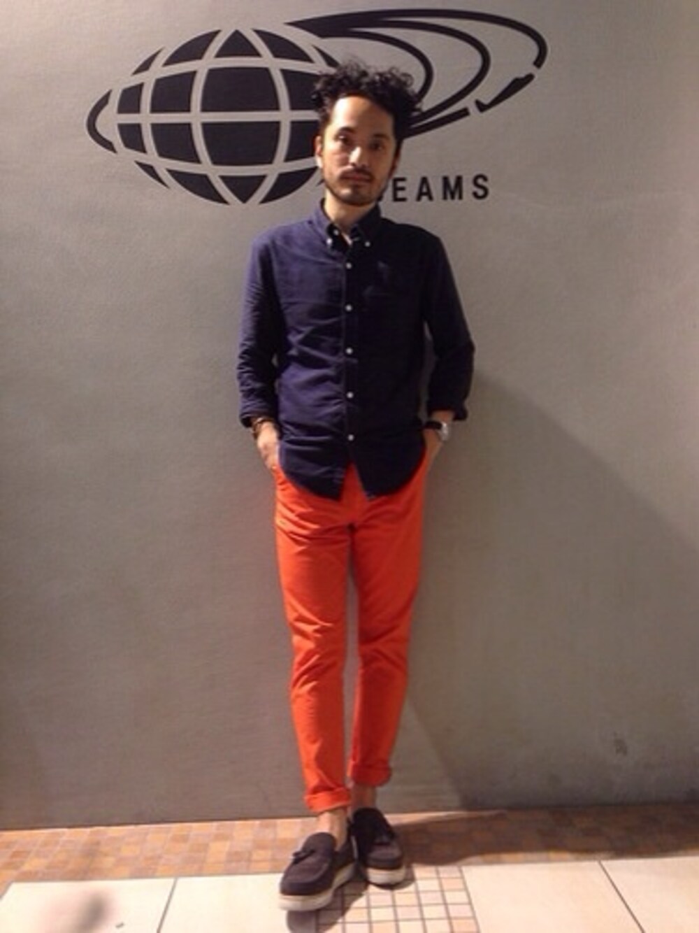 オレンジ系のチノパンツ、グレー系のその他シューズ、ブルー系のシャツ/ブラウスを着用したメンズの春コーディネートの1枚目の写真