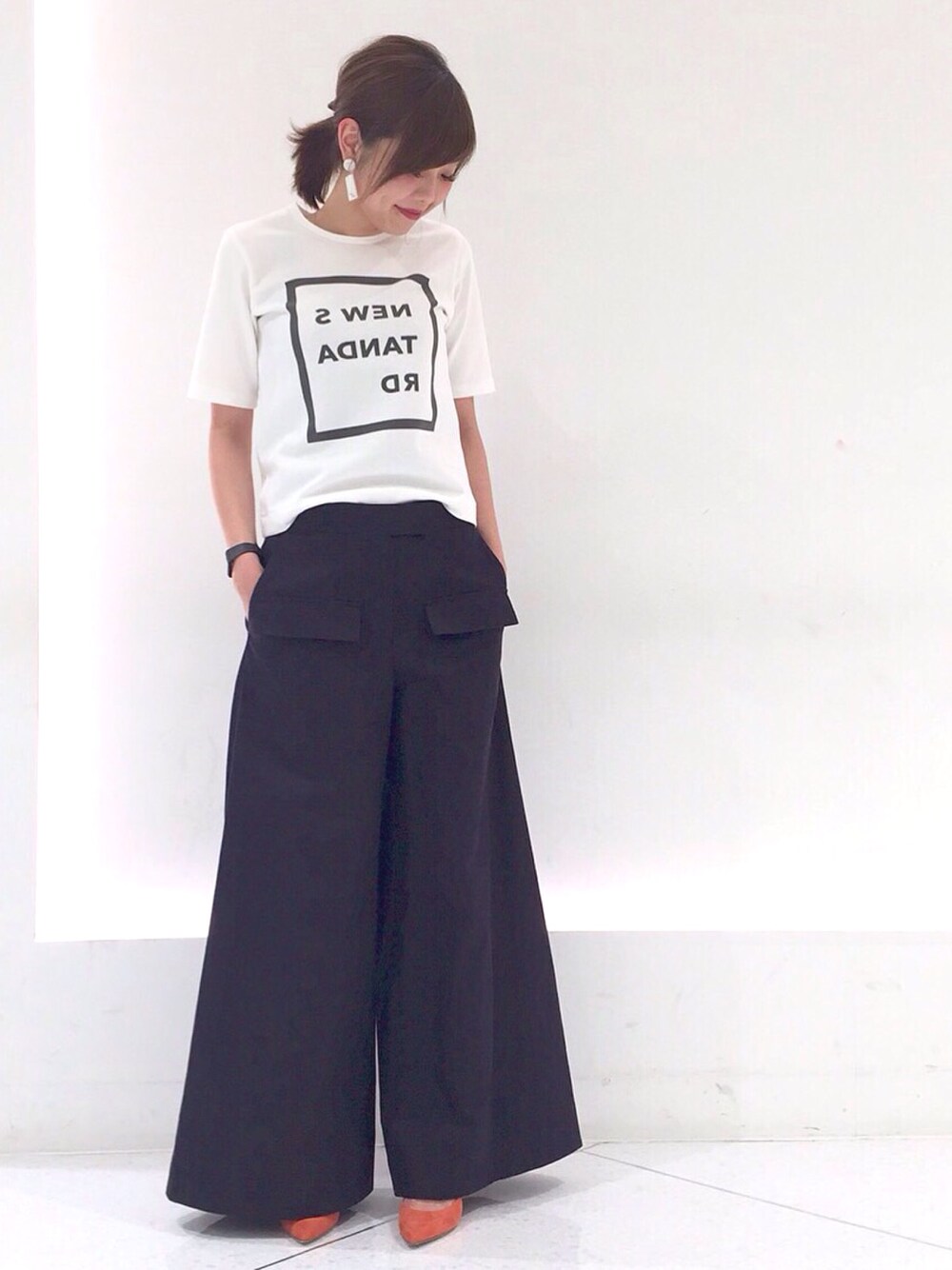 ホワイト系のTシャツ/カットソー、ブルー系のパンツ、オレンジ系のパンプスを着用したレディースの冬コーディネートの1枚目の写真