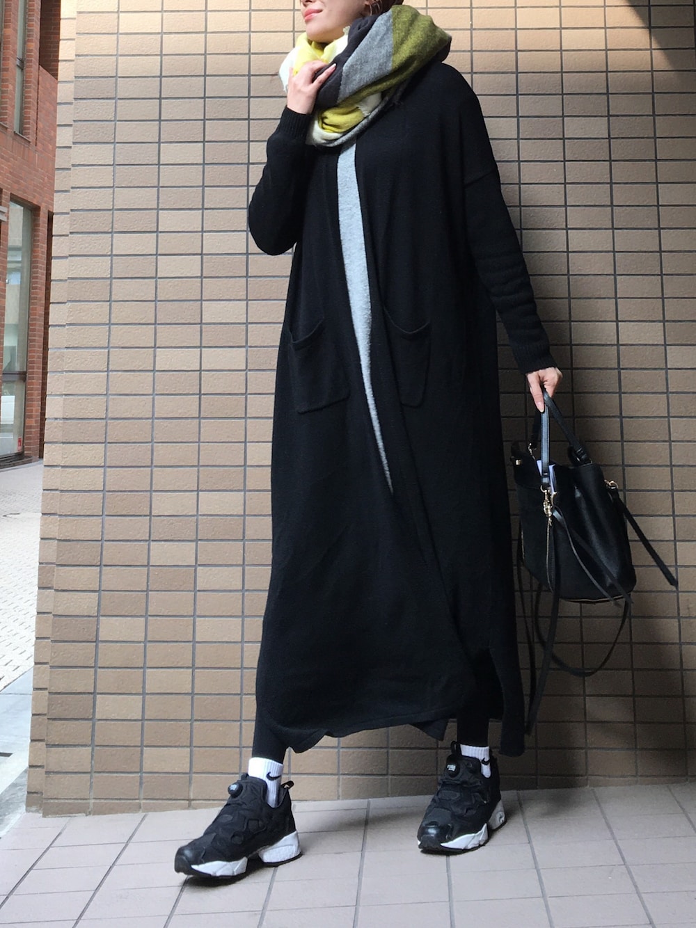 ブラック系のスニーカー、ブラック系のショルダーバッグ、ブラック系のジャケット/アウターを着用したレディースの冬コーディネートの1枚目の写真