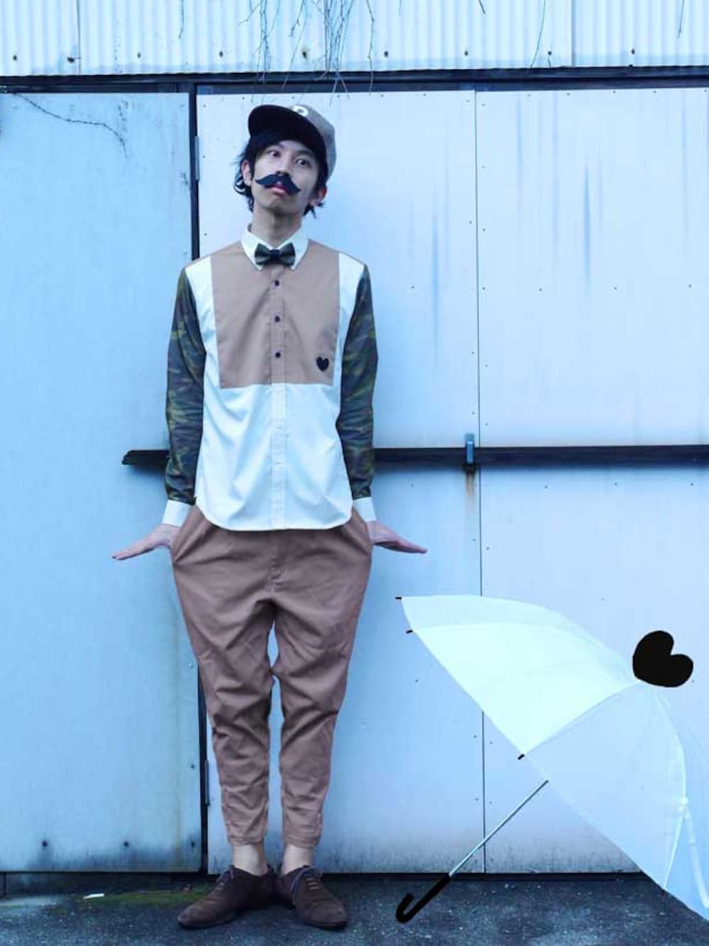 ベージュ系のシャツ/ブラウス、グレー系の蝶ネクタイ、ゴールド系のフィギュアを着用したメンズの夏コーディネートの1枚目の写真