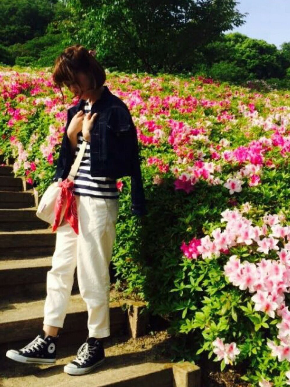 ブルー系のデニムジャケット、ブラック系のスニーカー、ホワイト系のTシャツ/カットソーを着用したレディースの春コーディネートの1枚目の写真