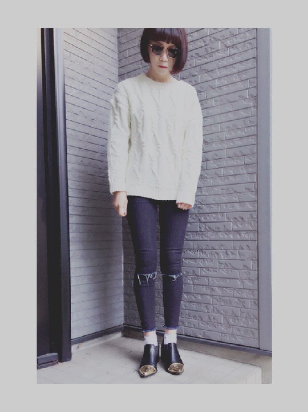 ホワイト系のニット/セーター、ブルー系のデニムパンツ、ゴールド系のシューズを着用したレディースの冬コーディネートの1枚目の写真