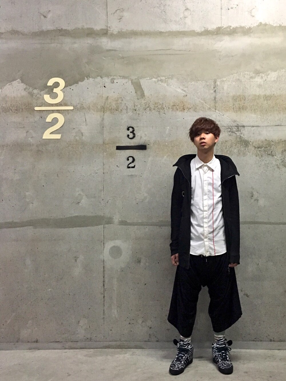 「ロングパーカー、比翼シャツ、変形ボトム、スニーカー、JULIUS、JILSANDER、Vivienne Westwood、Vivienne Westwood Man、adidas Originals by JEREMY SCOTT、黒と白」｜「MARC JACOBSのNYLON BIKER_BACKPACK（バックパック/リュック、ブラック系）」を使った、Honeyさん（メンズ・176cm）の春コーディネートの1枚目の写真