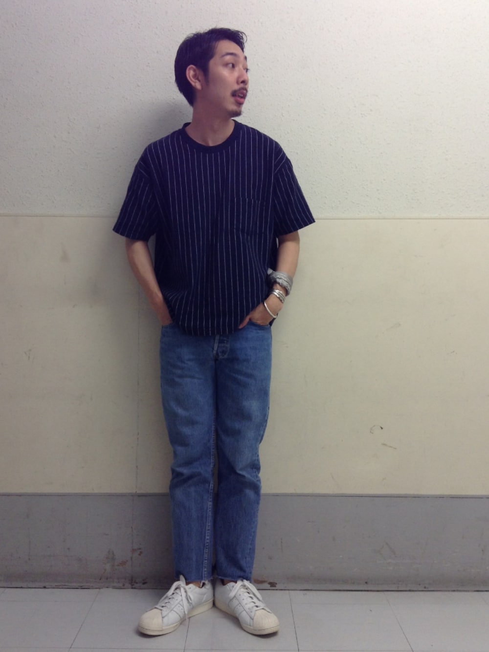 ブルー系のTシャツ/カットソー、ブルー系のデニムパンツ、ホワイト系のスニーカーを着用したメンズの夏コーディネートの1枚目の写真