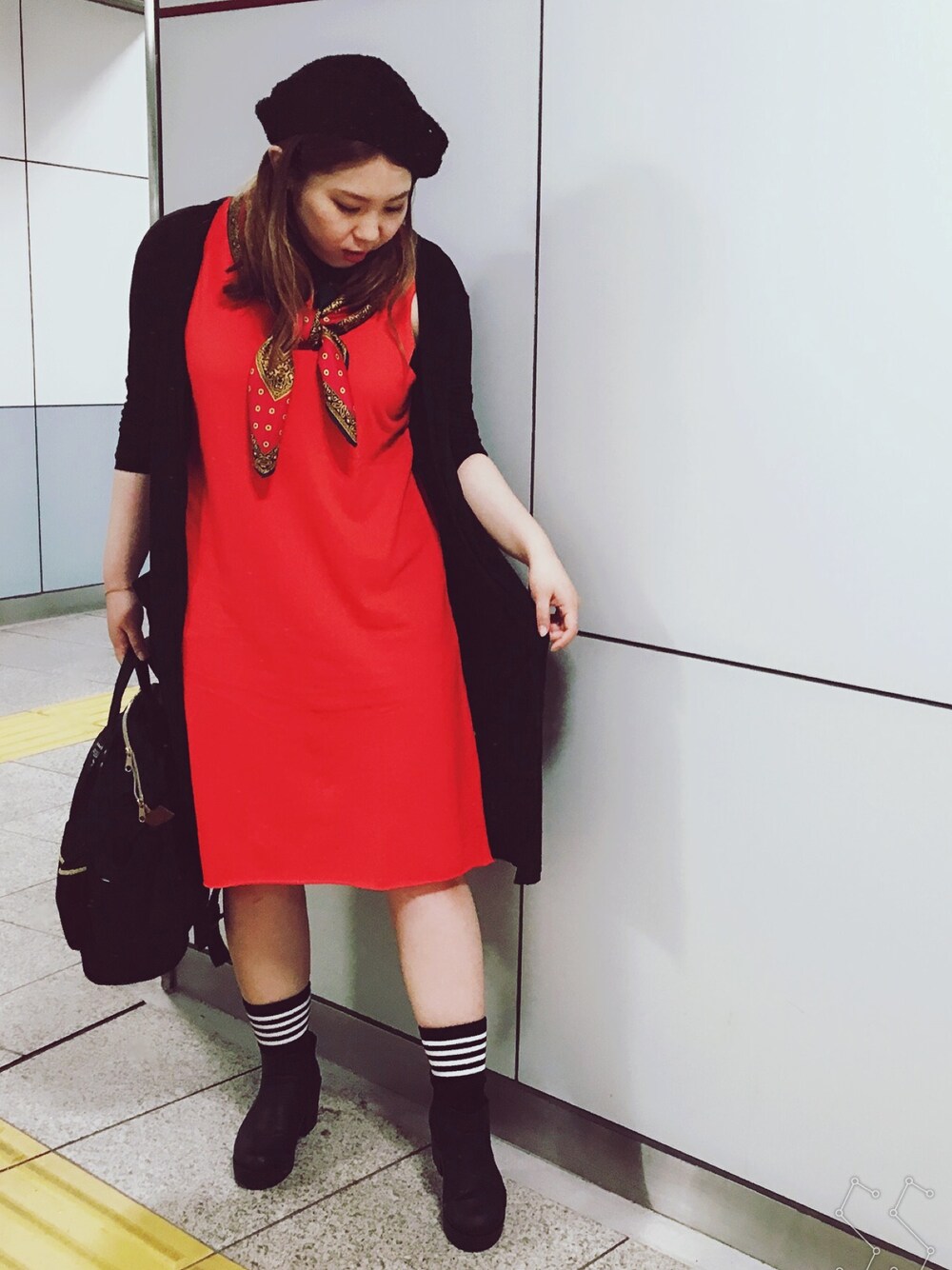 ブラック系のカーディガン/ボレロ、オレンジ系のワンピース、ブラック系のバックパック/リュックを着用したレディースの春コーディネートの1枚目の写真