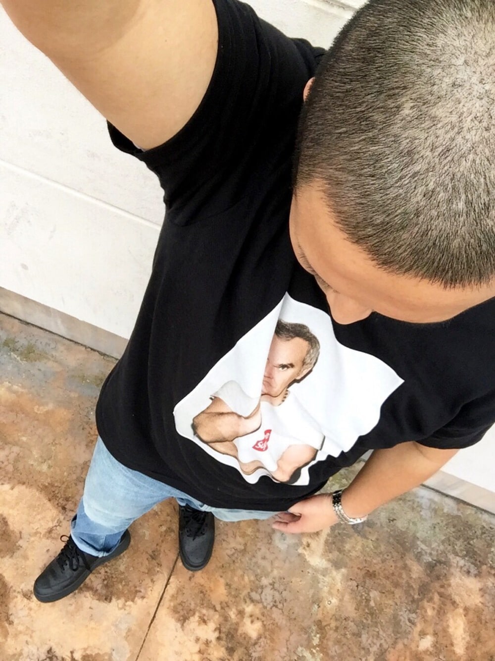 ブラック系のTシャツ/カットソー、ブルー系のデニムパンツ、ブラック系のスニーカーを着用したメンズの春コーディネートの1枚目の写真