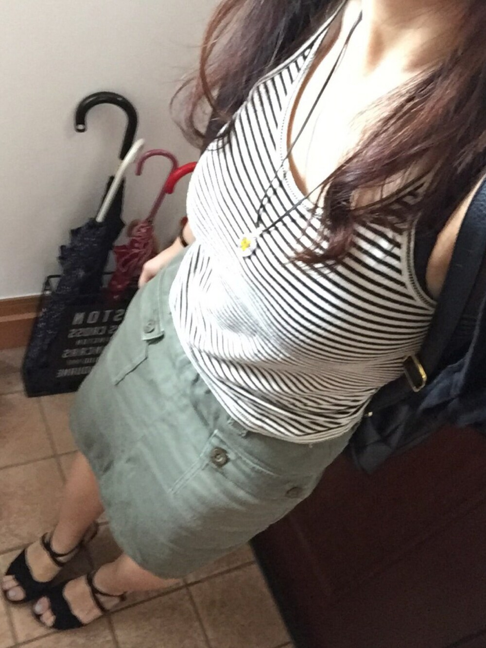 グリーン系のスカート、ブラック系のサンダルを着用したレディースの夏コーディネートの1枚目の写真