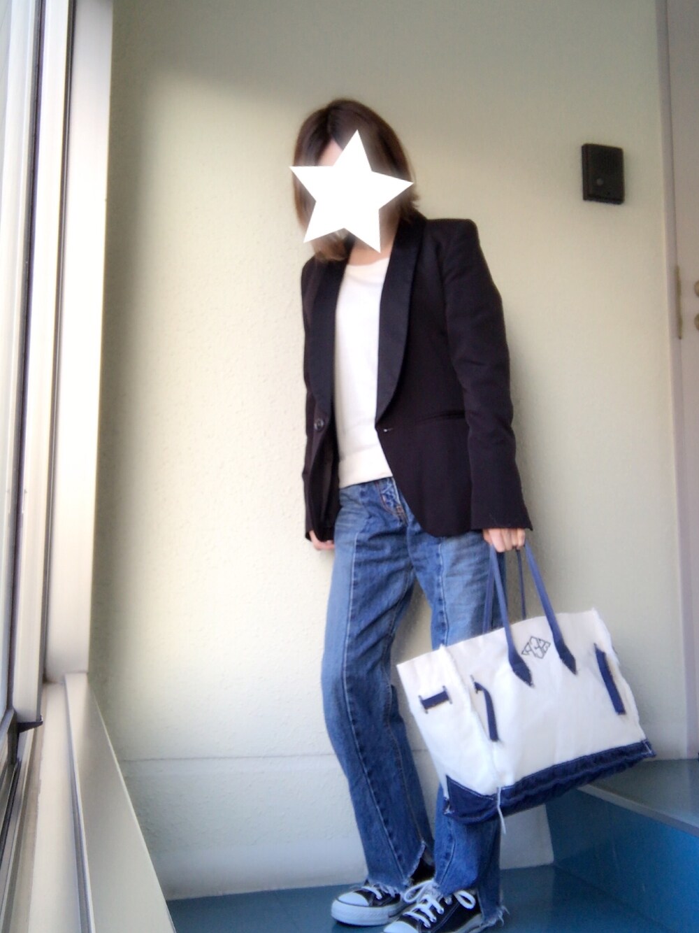 ブラック系のテーラードジャケット、ブルー系のデニムパンツ、ブラック系のスニーカーを着用したレディースの秋コーディネートの1枚目の写真