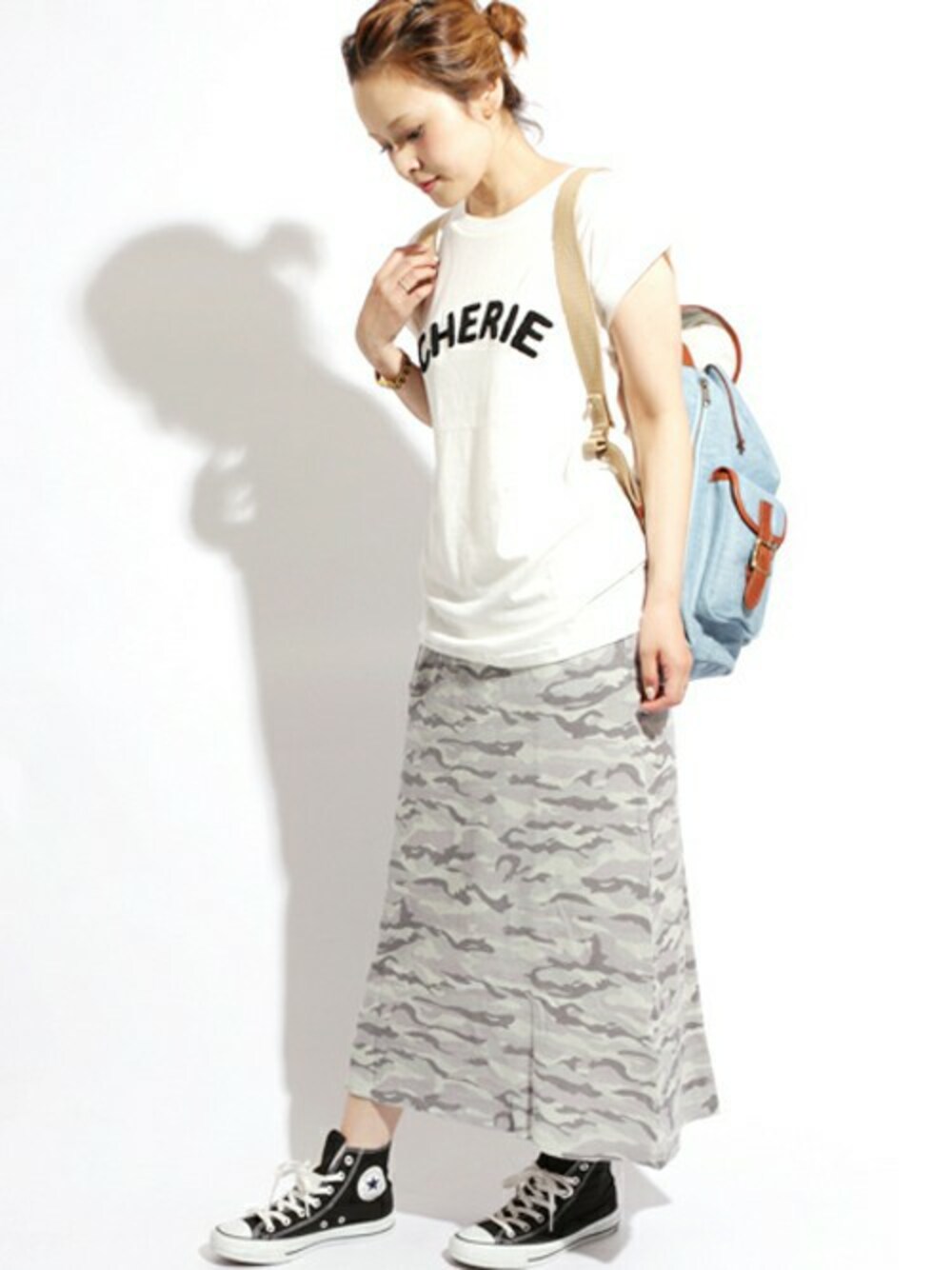 ブルー系のバックパック/リュック、ホワイト系のTシャツ/カットソー、グレー系のスカートを着用したレディースの夏コーディネートの1枚目の写真