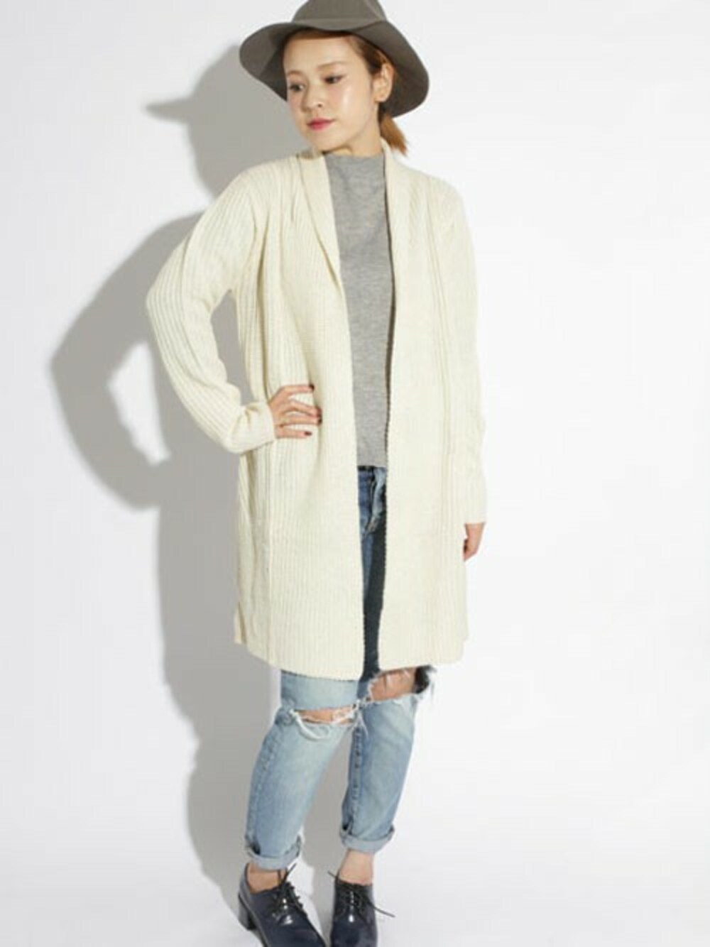 ブルー系のデニムパンツ、ホワイト系のカーディガン/ボレロ、グレー系のニット/セーターを着用したレディースの秋コーディネートの1枚目の写真