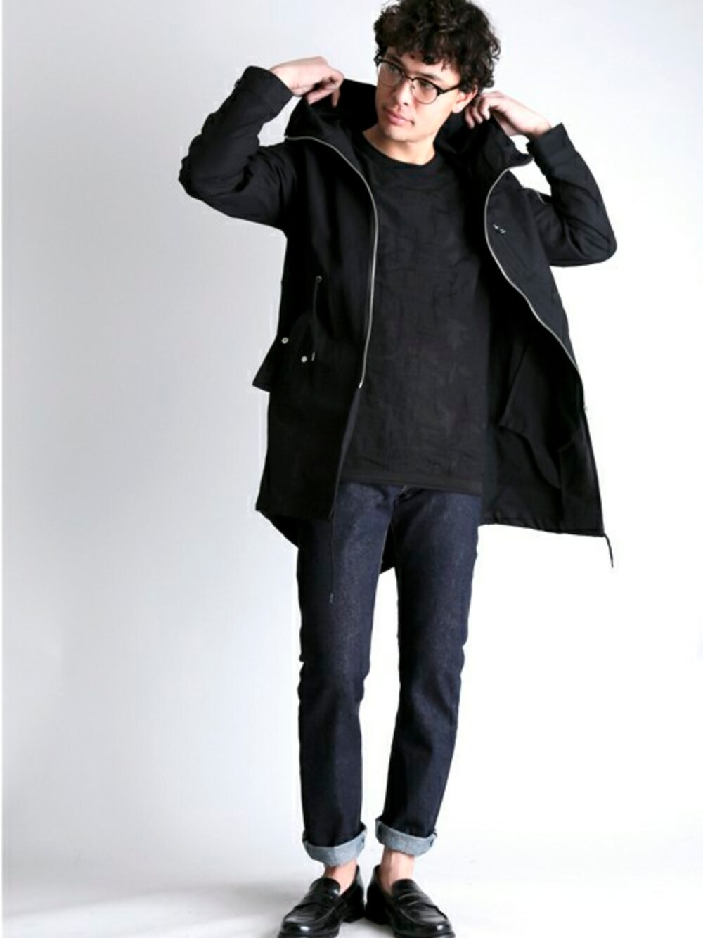 ブラック系のモッズコート、ブラック系のニット/セーター、ブルー系のデニムパンツを着用したメンズの冬コーディネートの1枚目の写真