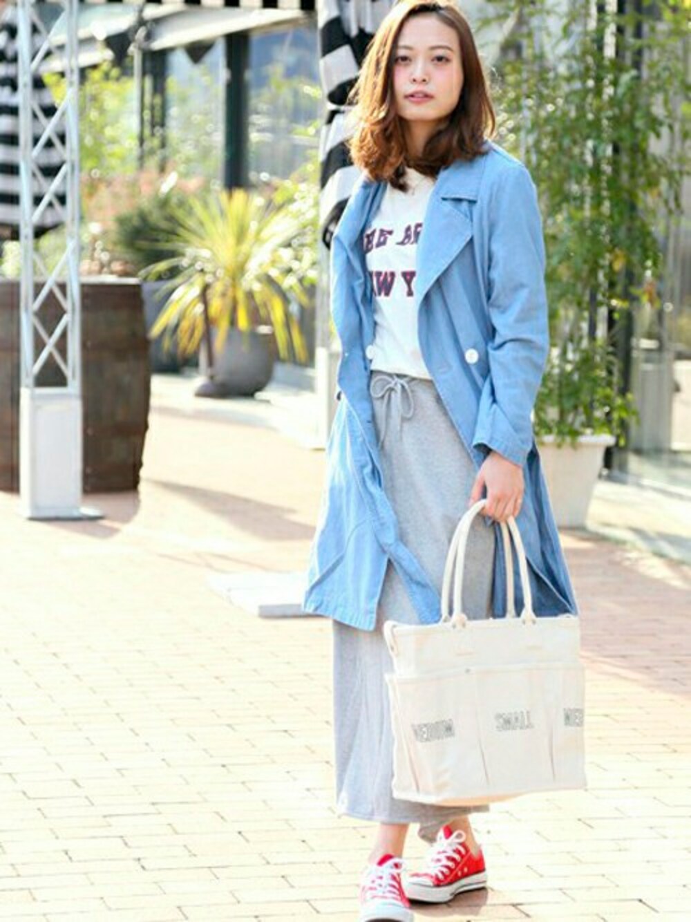 ブルー系のトレンチコート、ホワイト系のTシャツ/カットソー、グレー系のスカートを着用したレディースの春コーディネートの1枚目の写真