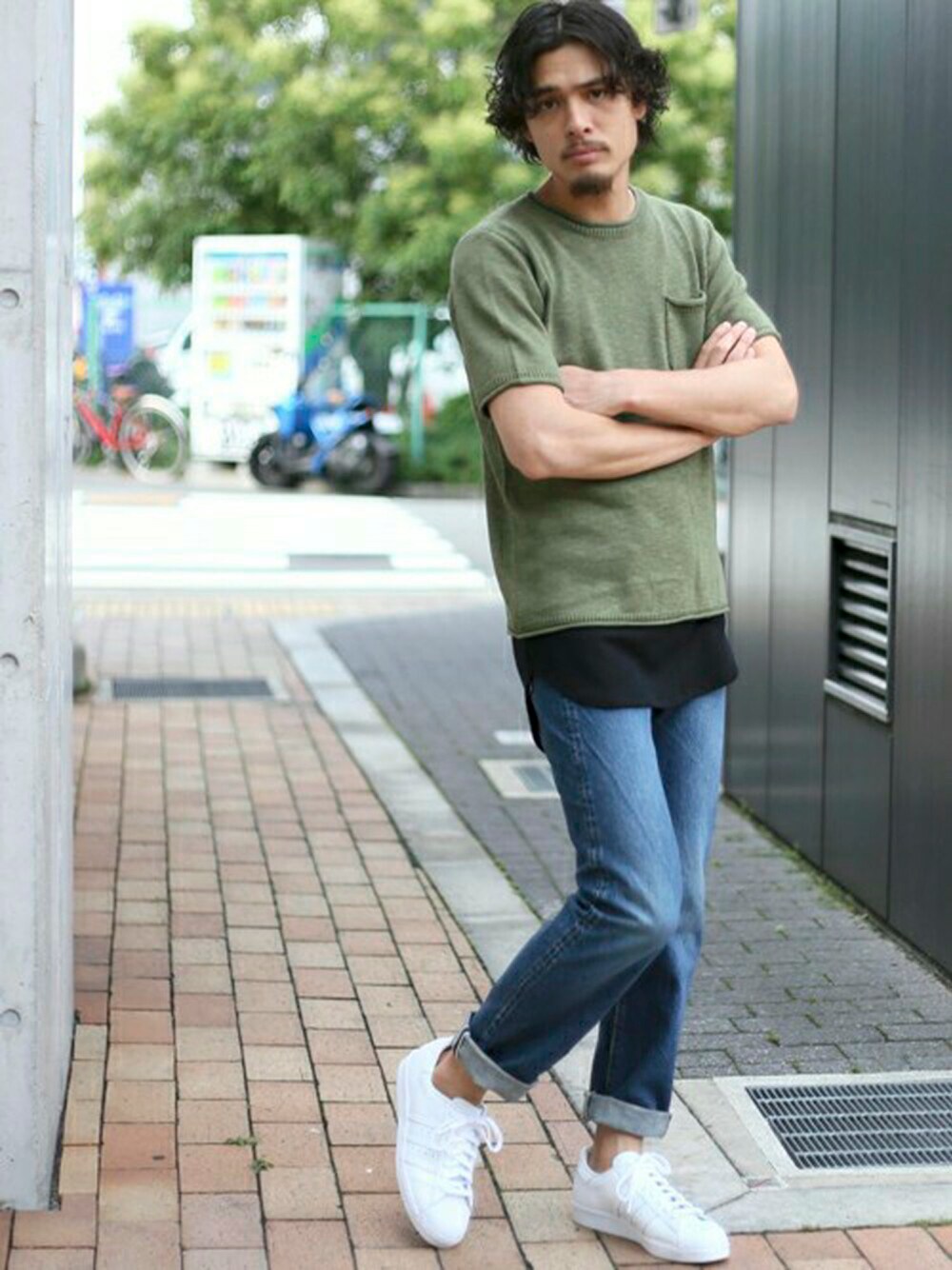 ホワイト系のスニーカー、ブルー系のデニムパンツ、グリーン系のニット/セーターを着用したメンズの夏コーディネートの1枚目の写真