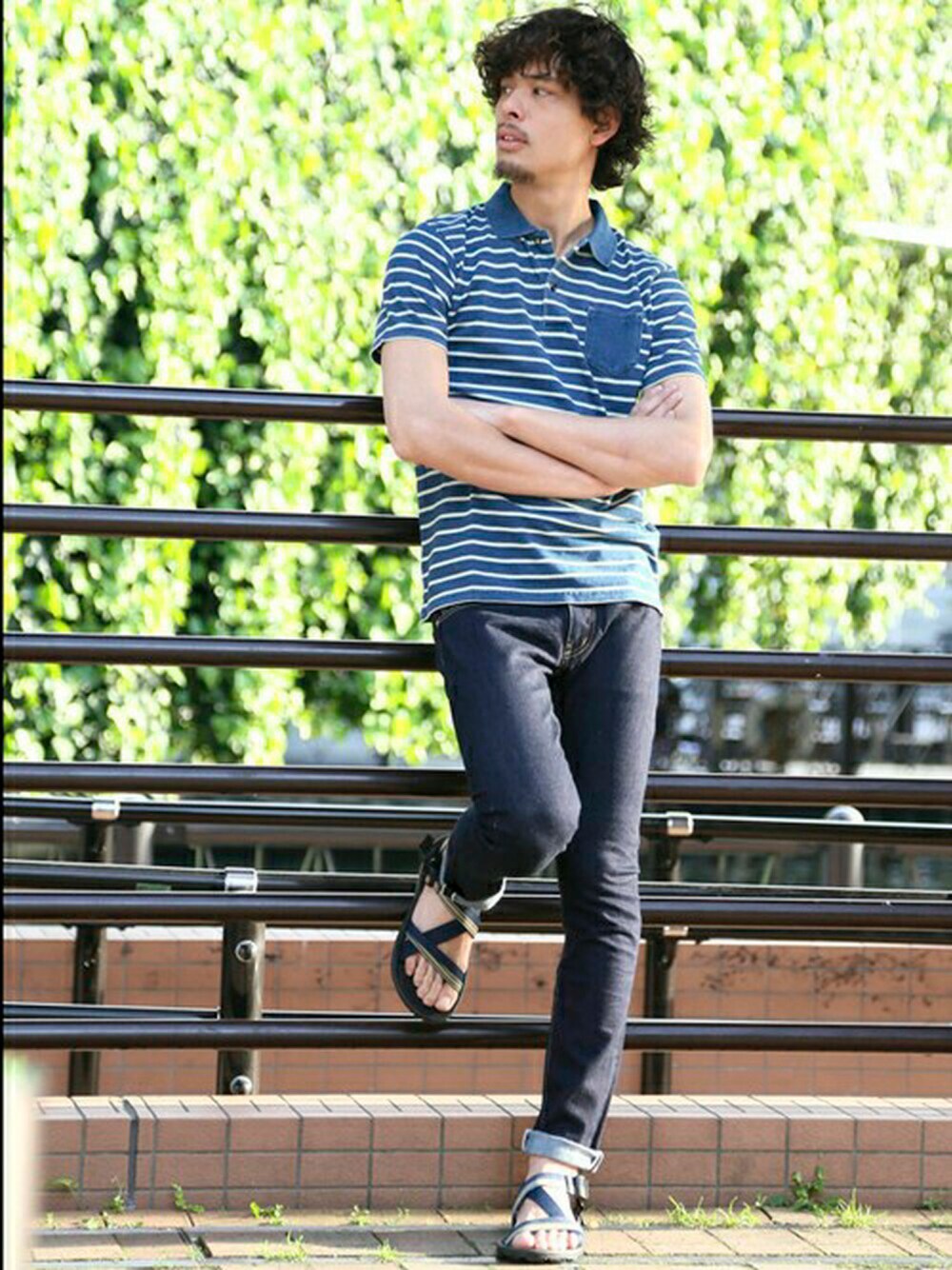 ブルー系のデニムパンツ、ブルー系のポロシャツ、ブルー系のサンダルを着用したメンズの夏コーディネートの1枚目の写真