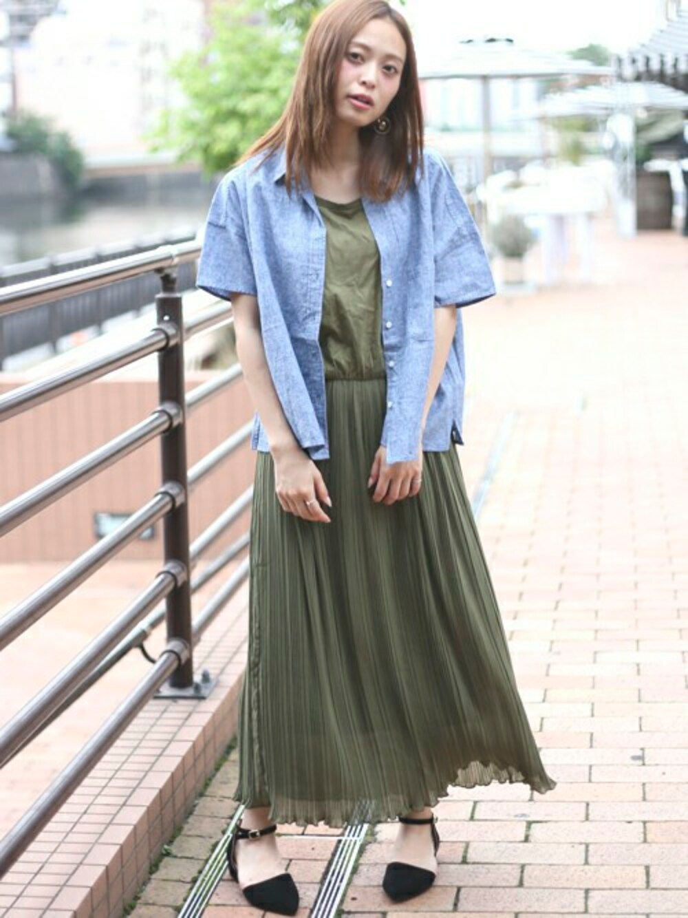 グリーン系のワンピース、ブラック系のパンプス、ブルー系のシャツ/ブラウスを着用したレディースの夏コーディネートの1枚目の写真