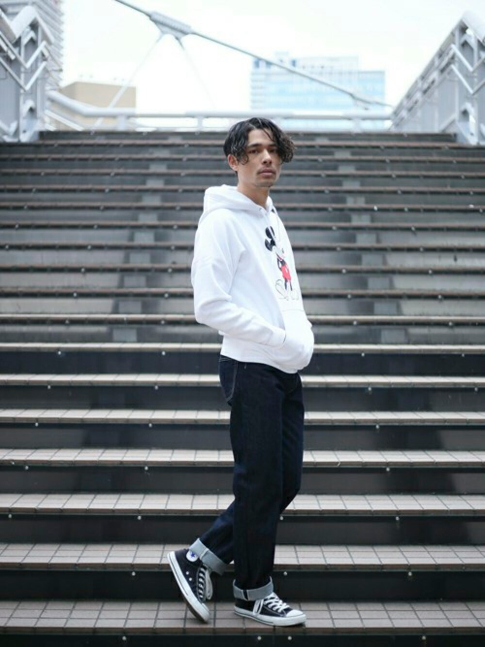 ホワイト系のパーカー、ブラック系のTシャツ/カットソー、ブルー系のデニムパンツを着用したメンズの春コーディネートの1枚目の写真