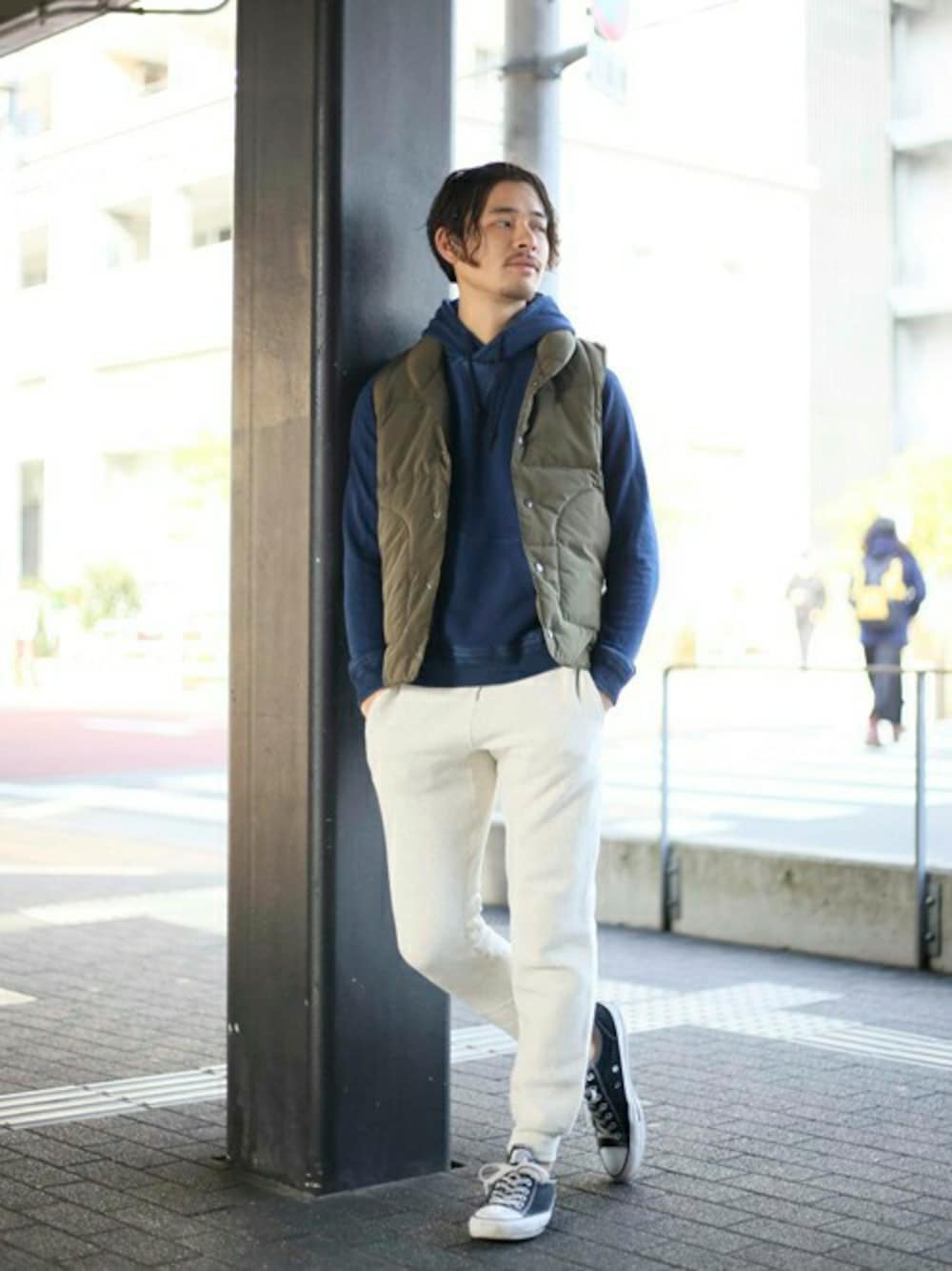 グリーン系のダウンベスト、ブルー系のパーカー、ベージュ系のその他パンツを着用したメンズの冬コーディネートの1枚目の写真