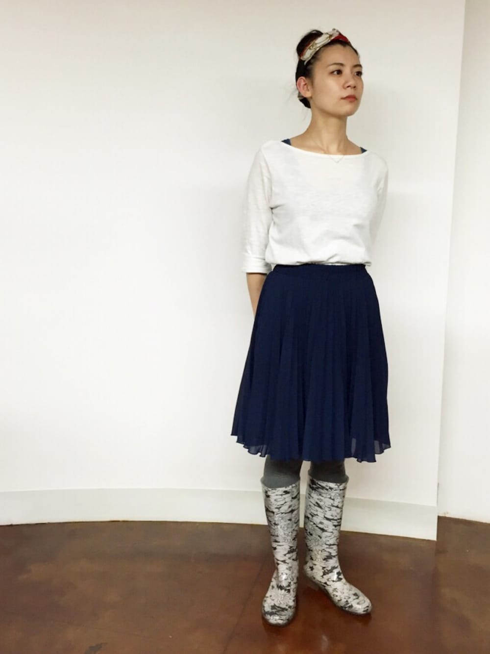 ブルー系のスカート、ホワイト系のレインシューズ、ホワイト系のTシャツ/カットソーを着用したレディースの夏コーディネートの1枚目の写真