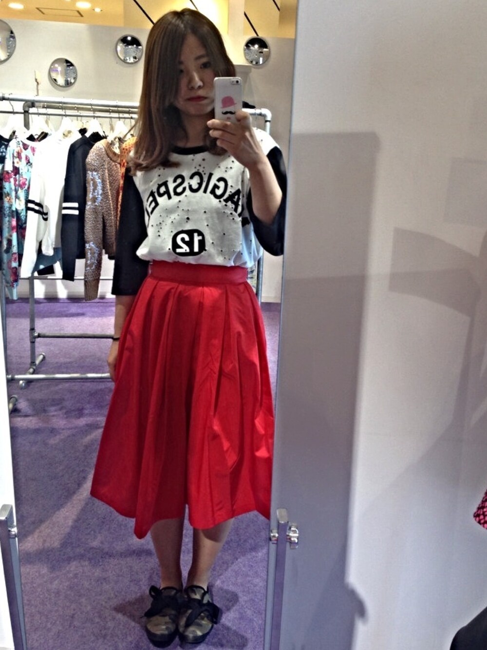 レッド系のスカート、ブラック系のTシャツ/カットソーを着用したレディースの夏コーディネートの1枚目の写真