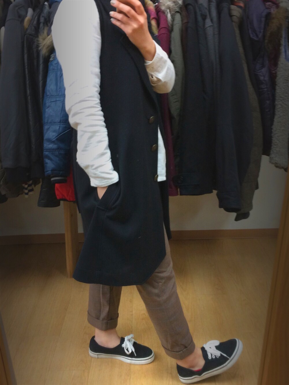 ブラック系のベスト、ホワイト系のシャツ/ブラウス、ブラウン系のチノパンツを着用したレディースの秋コーディネートの1枚目の写真