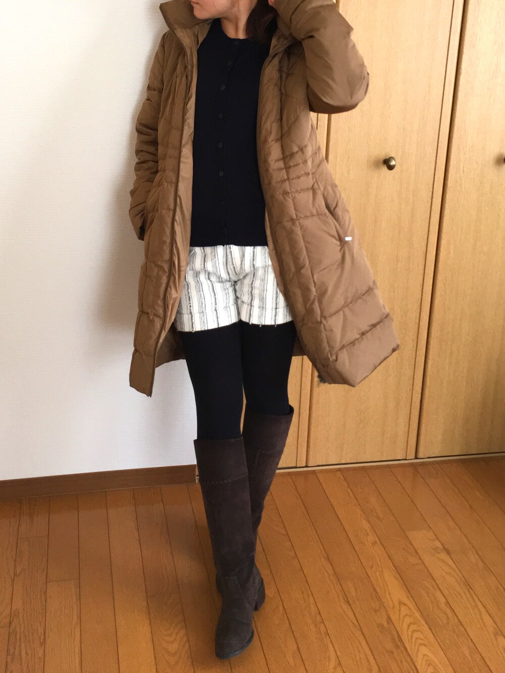 ブラウン系のダウンジャケット/コート、ブルー系のニット/セーター、ホワイト系のその他パンツを着用したレディースの秋コーディネートの1枚目の写真