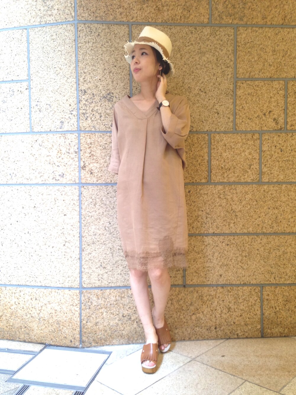 イエロー系のワンピース、イエロー系のサンダル、ベージュ系のハットを着用したレディースの夏コーディネートの1枚目の写真
