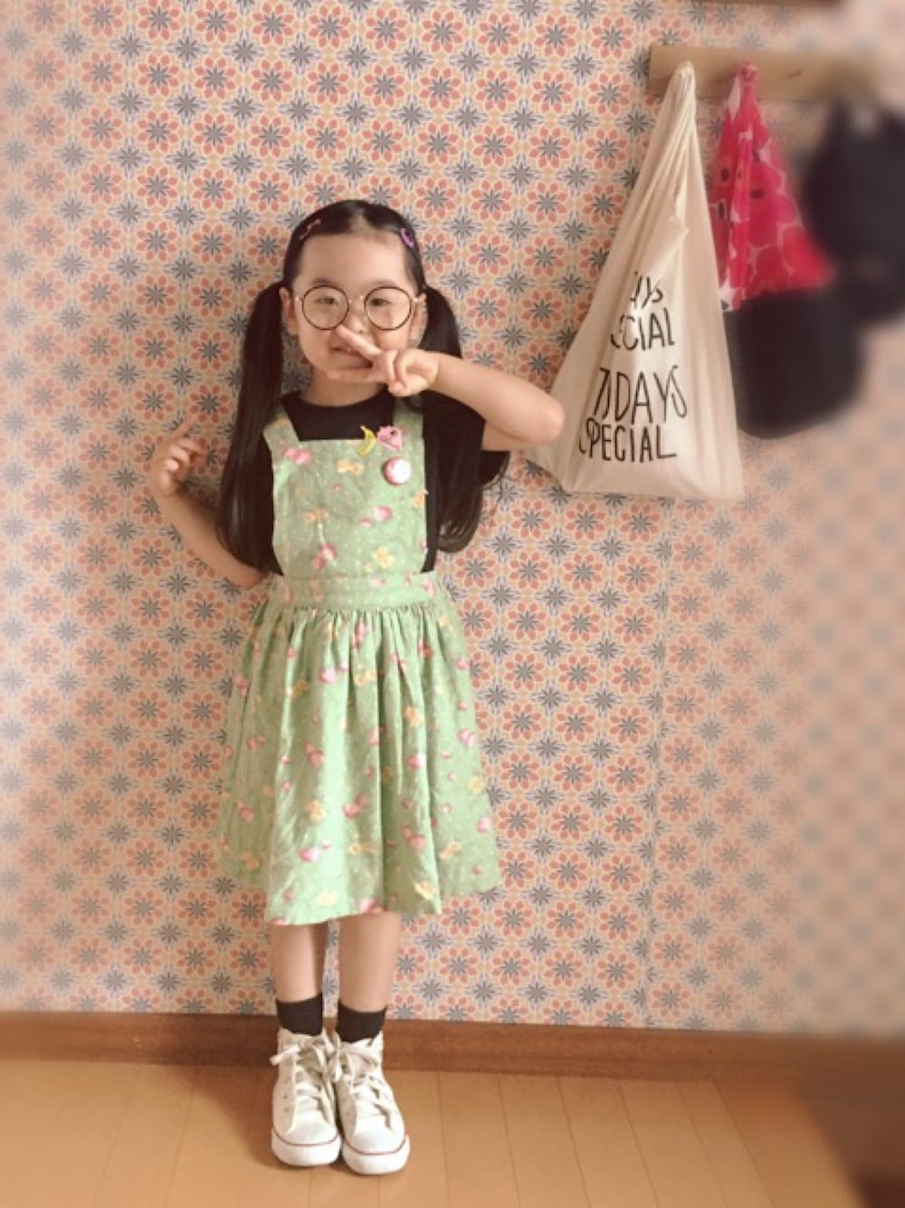 グリーン系のワンピース、その他のヘアピン、ブラウン系のメガネを着用したキッズの秋コーディネートの1枚目の写真
