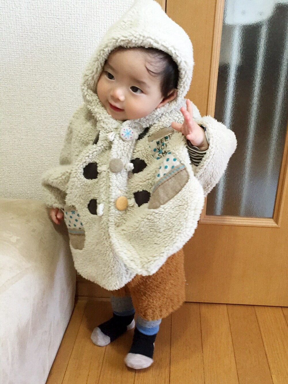 ベージュ系のポンチョ、ブラウン系のその他パンツ、グレー系のレギンス/スパッツを着用したキッズの冬コーディネートの1枚目の写真