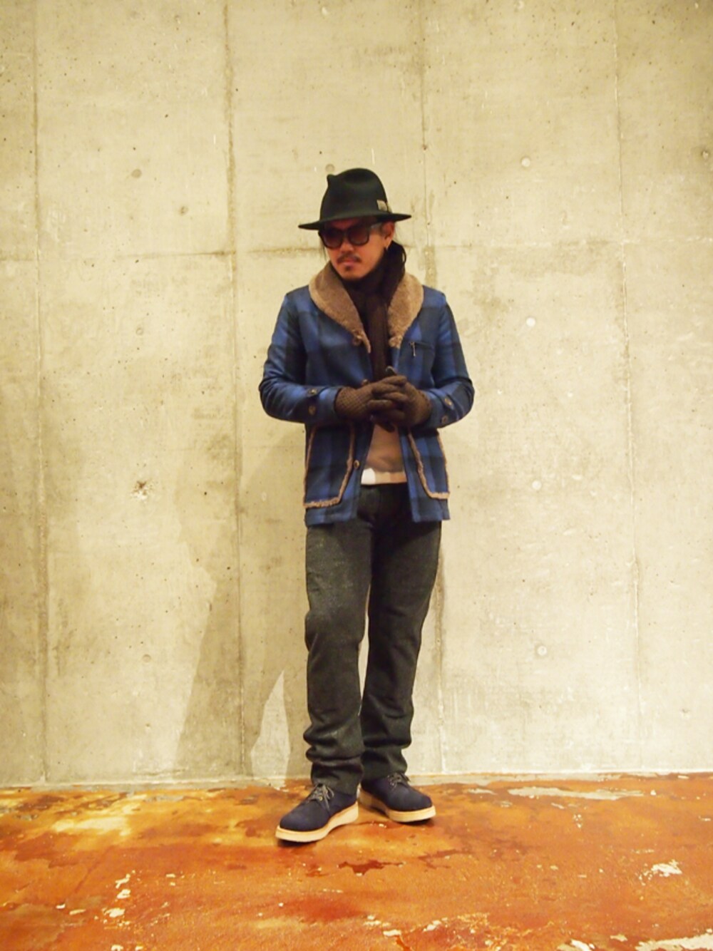 ブルー系のカバーオール、ブルー系のブーツ、ブラウン系の手袋を着用したメンズの秋コーディネートの1枚目の写真
