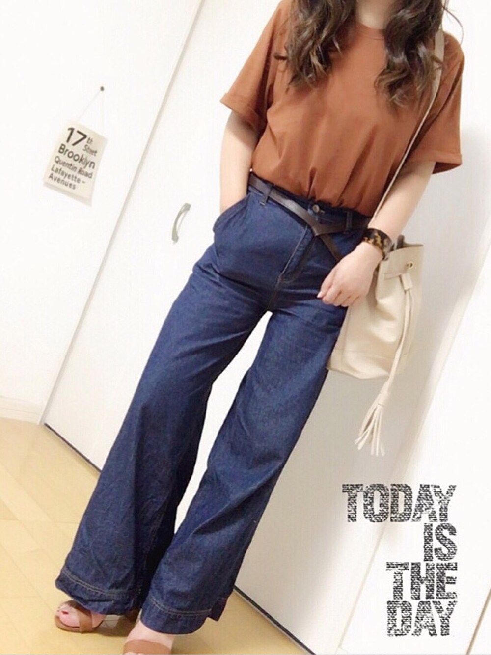 ブラウン系のTシャツ/カットソー、ブルー系のデニムパンツ、ベージュ系のショルダーバッグを着用したレディースの夏コーディネートの1枚目の写真