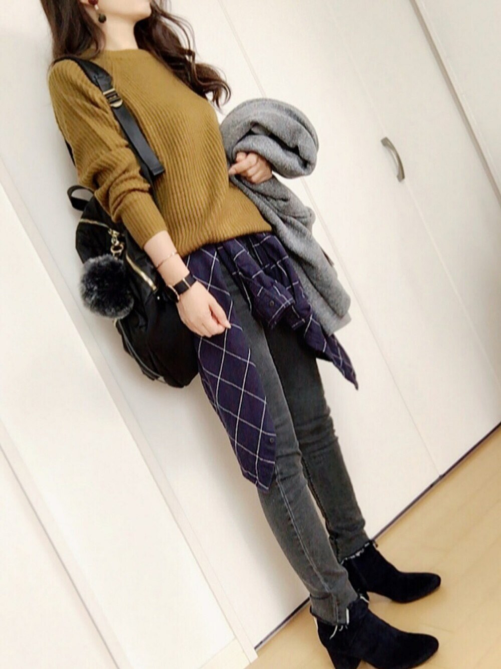 イエロー系のニット/セーター、ブルー系のシャツ/ブラウス、グレー系のデニムパンツを着用したレディースの秋コーディネートの1枚目の写真