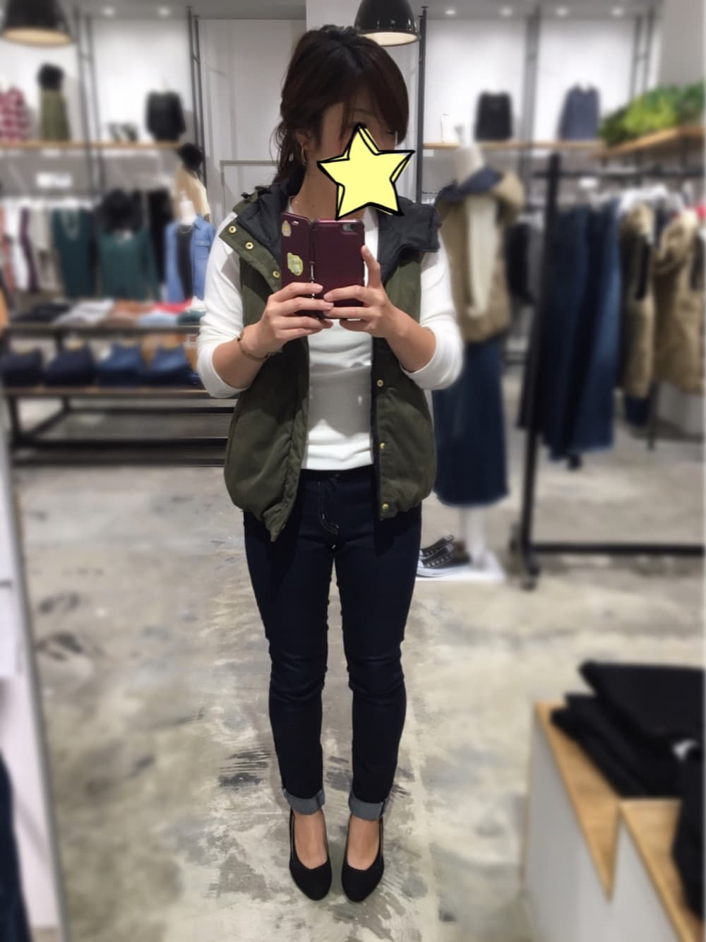 ホワイト系のTシャツ/カットソー、グリーン系のダウンベスト、ブルー系のデニムパンツを着用したレディースの秋コーディネートの1枚目の写真