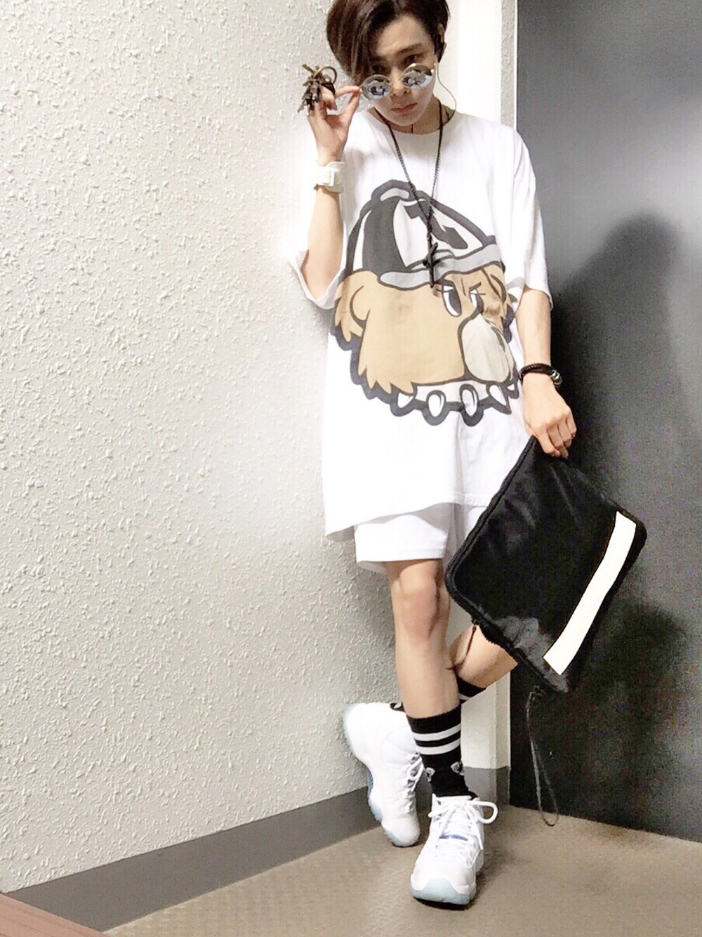 ホワイト系のTシャツ/カットソー、ホワイト系のパンツ、ブラック系のクラッチバッグを着用したメンズの夏コーディネートの1枚目の写真