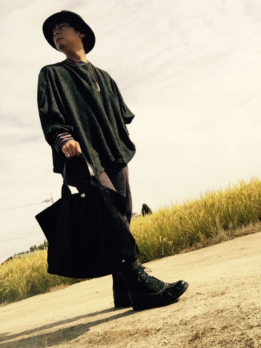 グレー系のポンチョ、ブラウン系のTシャツ/カットソー、グレー系のブーツを着用したメンズの秋コーディネートの1枚目の写真