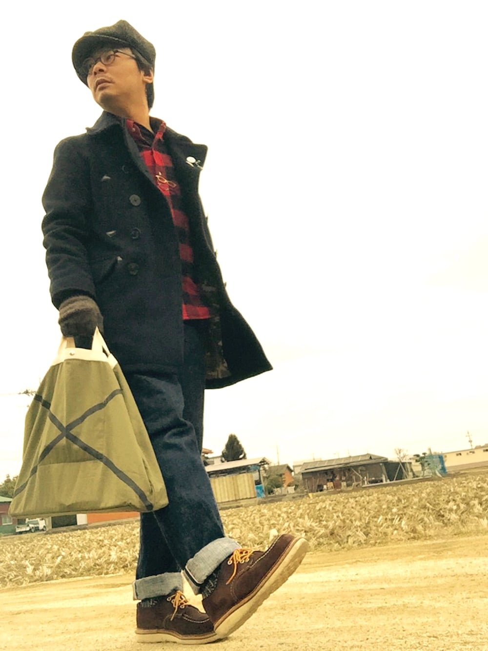 ブルー系のピーコート、レッド系のシャツ/ブラウス、ブルー系のデニムパンツを着用したメンズの冬コーディネートの1枚目の写真