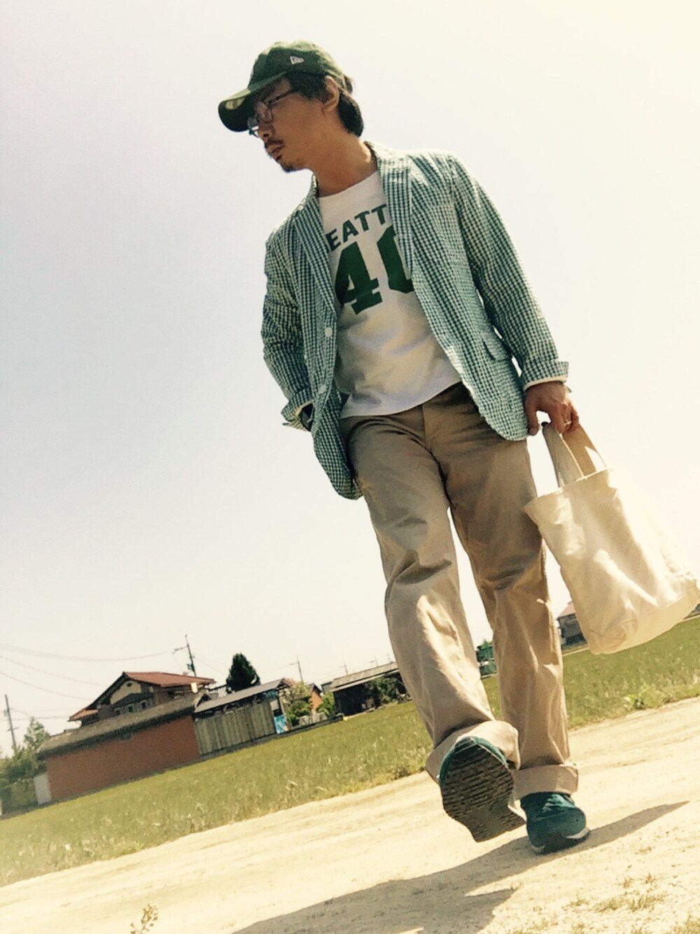 グリーン系のその他アウター、ホワイト系のTシャツ/カットソー、ベージュ系のチノパンツを着用したメンズの春コーディネートの1枚目の写真