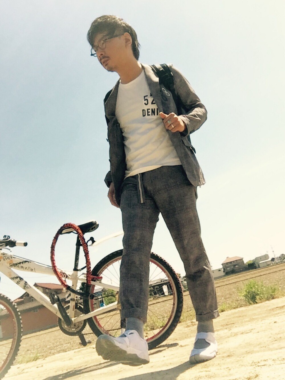 グレー系のテーラードジャケット、ホワイト系のTシャツ/カットソー、ブルー系のビジネスバッグを着用したメンズの春コーディネートの1枚目の写真