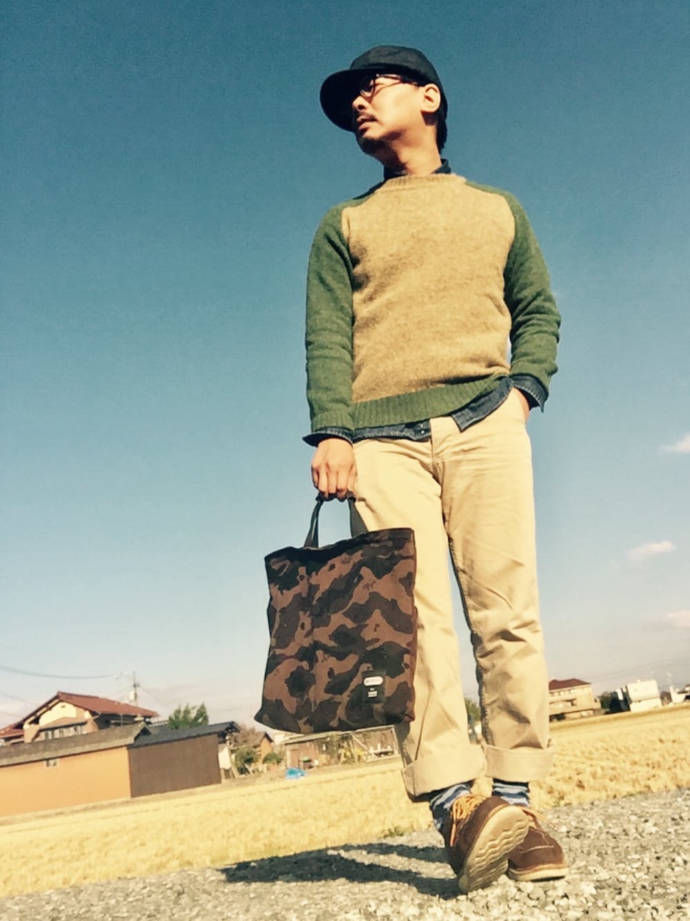 ベージュ系のニット/セーター、ブルー系のシャツ/ブラウス、ベージュ系のチノパンツを着用したメンズの秋コーディネートの1枚目の写真