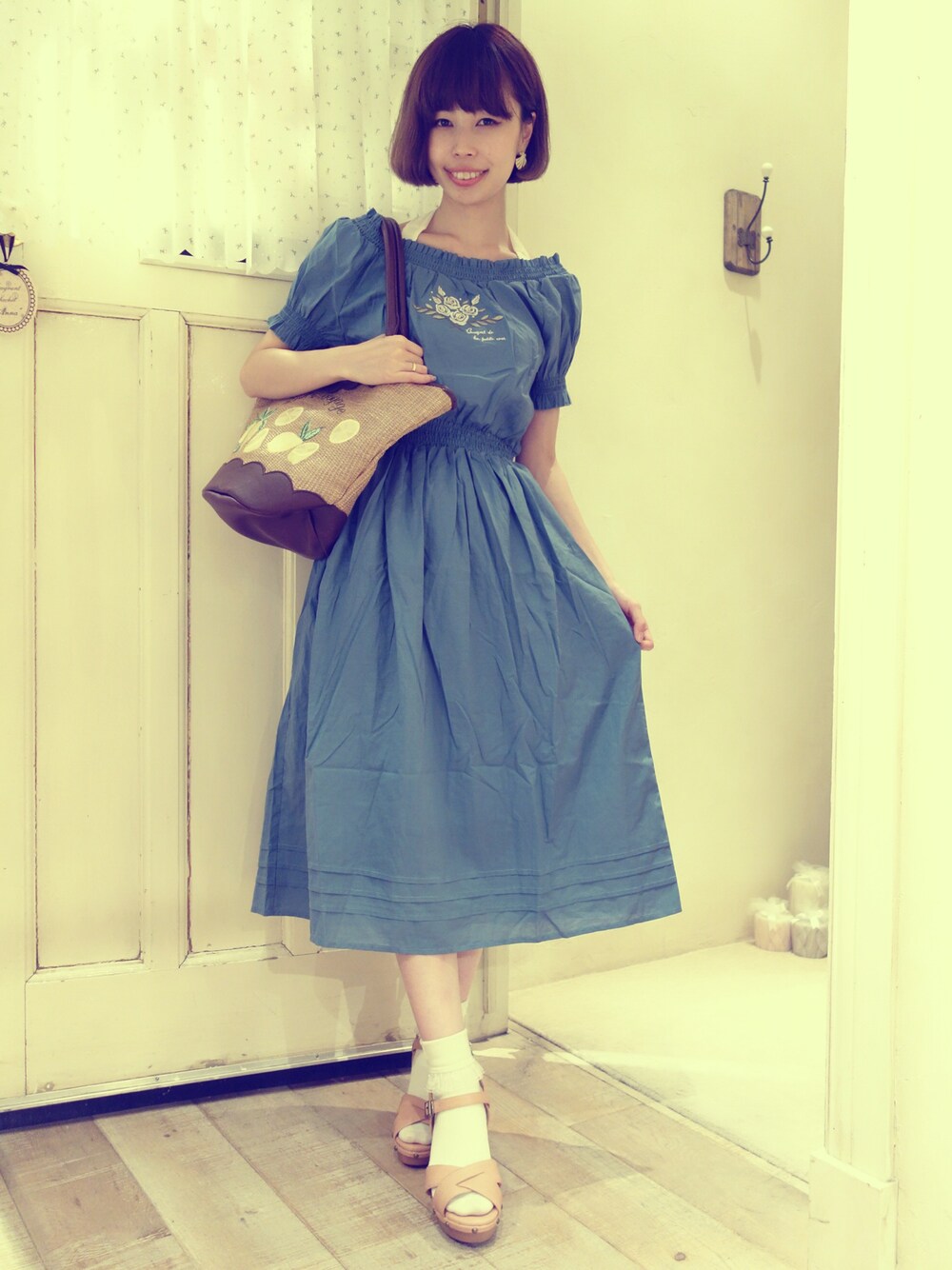 ブルー系のワンピース、ホワイト系のTシャツ/カットソー、ブラウン系のかごバッグを着用したレディースの夏コーディネートの1枚目の写真