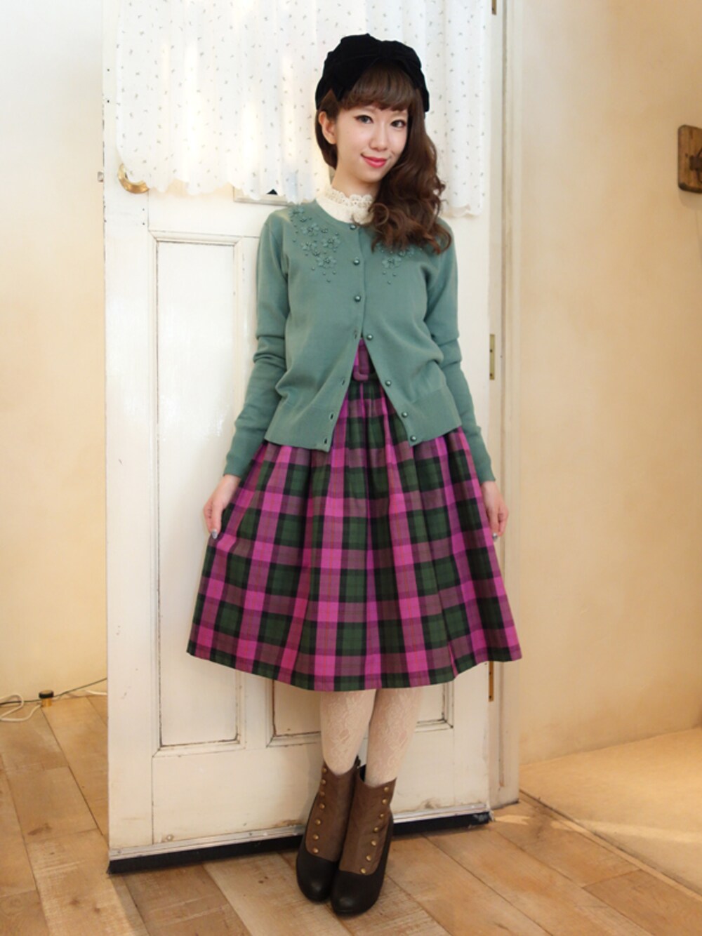 グリーン系のカーディガン/ボレロ、パープル系のスカート、ホワイト系のシャツ/ブラウスを着用したレディースの夏コーディネートの1枚目の写真