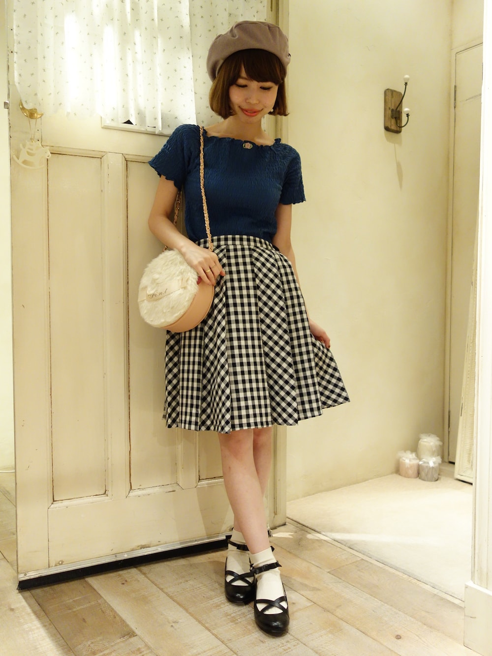 ベージュ系のショルダーバッグ、ブラック系のスカート、ブルー系のTシャツ/カットソーを着用したレディースの夏コーディネートの1枚目の写真