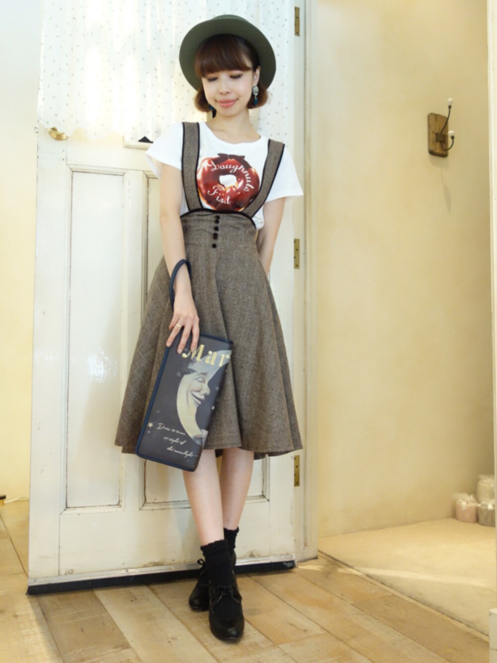 ブラウン系のスカート、ホワイト系のTシャツ/カットソー、グレー系のクラッチバッグを着用したレディースの夏コーディネートの1枚目の写真