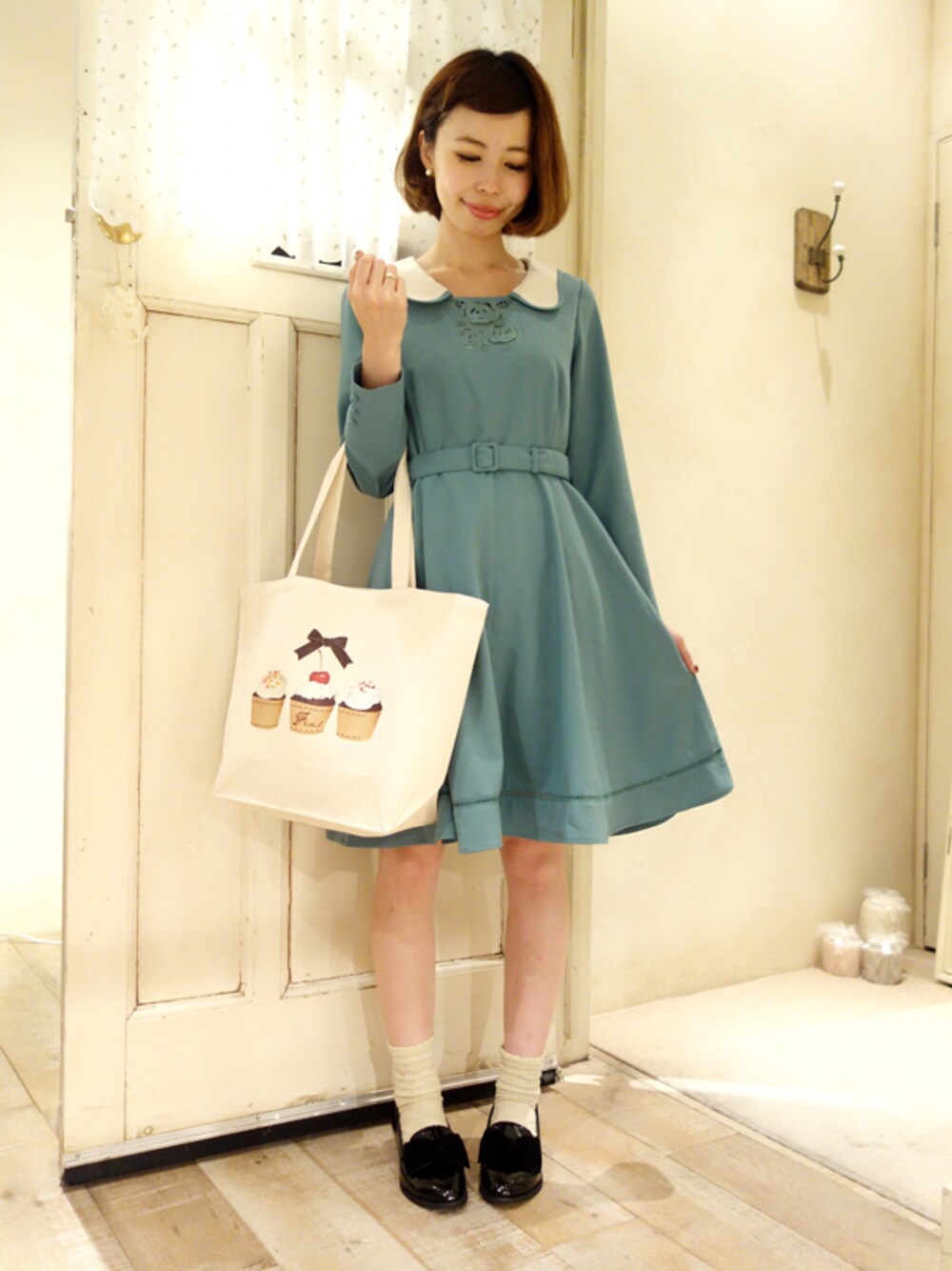 グリーン系のワンピース、ベージュ系のトートバッグ、ブラック系のその他シューズを着用したレディースの秋コーディネートの1枚目の写真