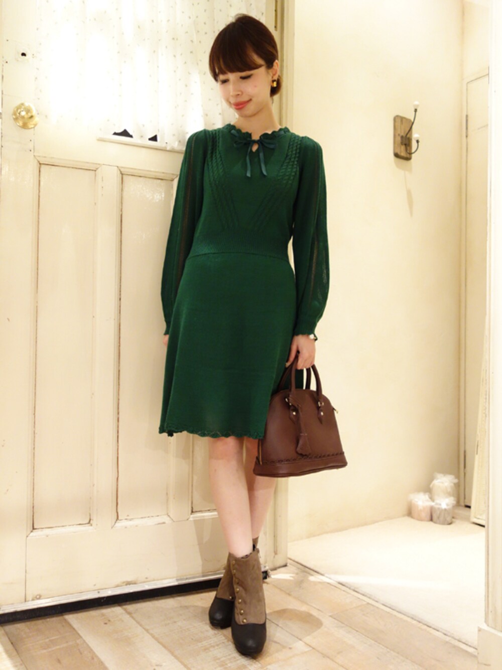 グリーン系のワンピース、グリーン系のブーツ、ブルー系のボストンバッグを着用したレディースの秋コーディネートの1枚目の写真
