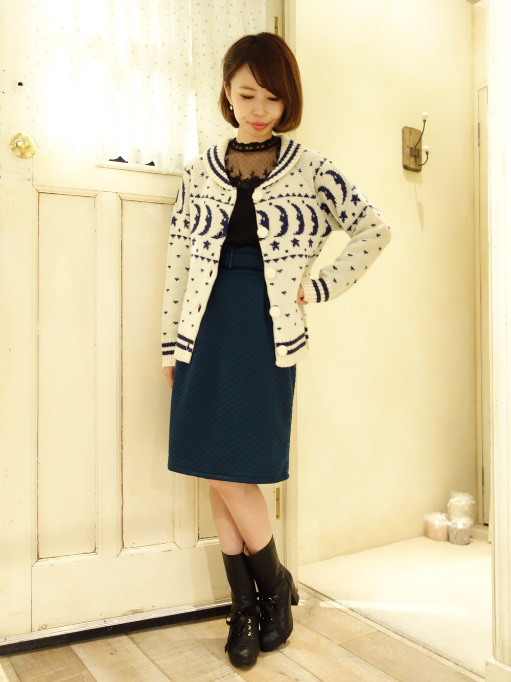 グリーン系のスカートを着用したレディースの秋コーディネートの1枚目の写真