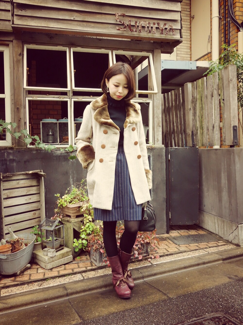 グリーン系のブーツ、ベージュ系のテーラードジャケット、ブラック系のニット/セーターを着用したレディースの秋コーディネートの1枚目の写真