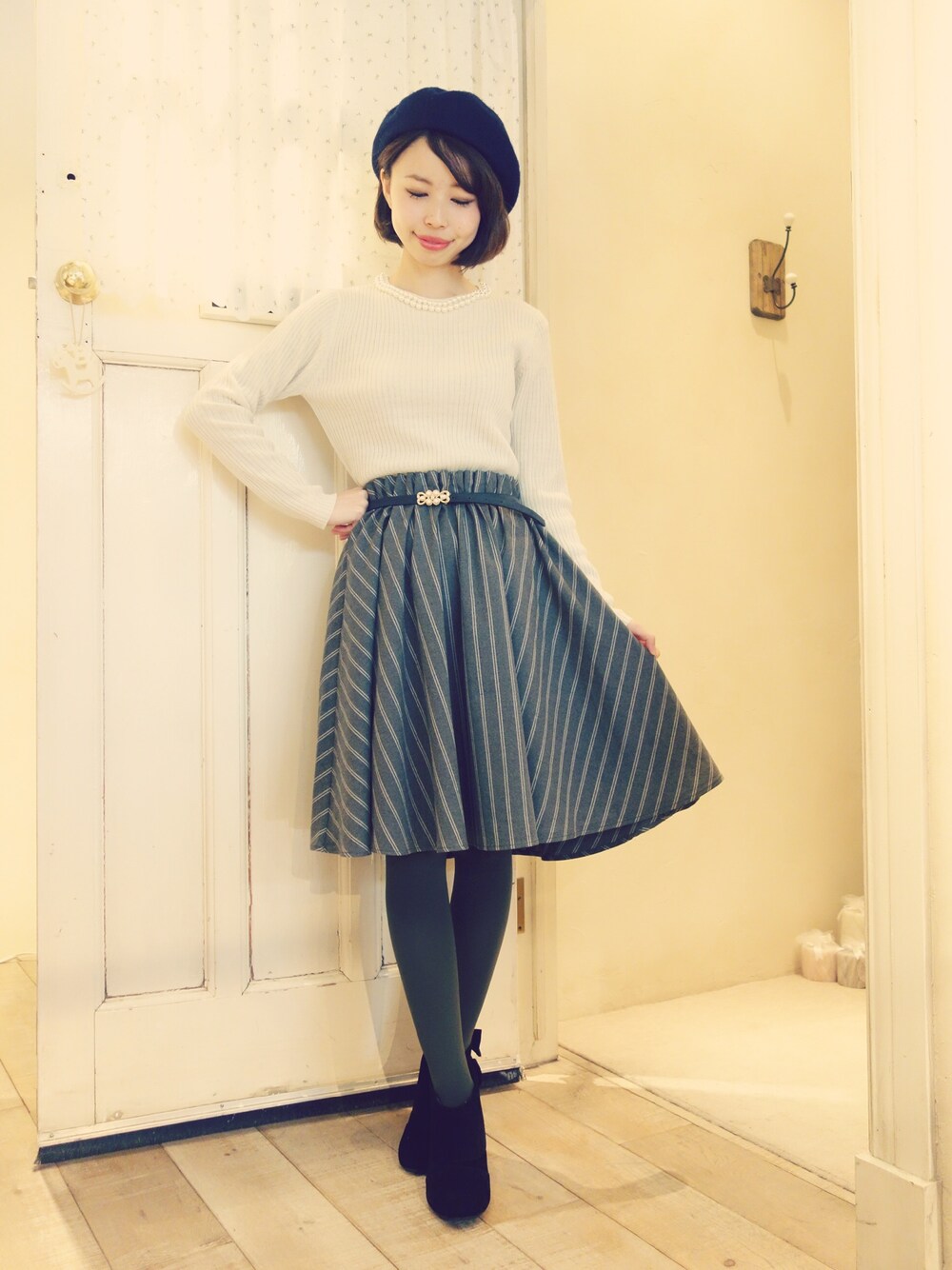 ブラック系のブーティ、グレー系のスカート、ブラック系のニット/セーターを着用したレディースの秋コーディネートの1枚目の写真